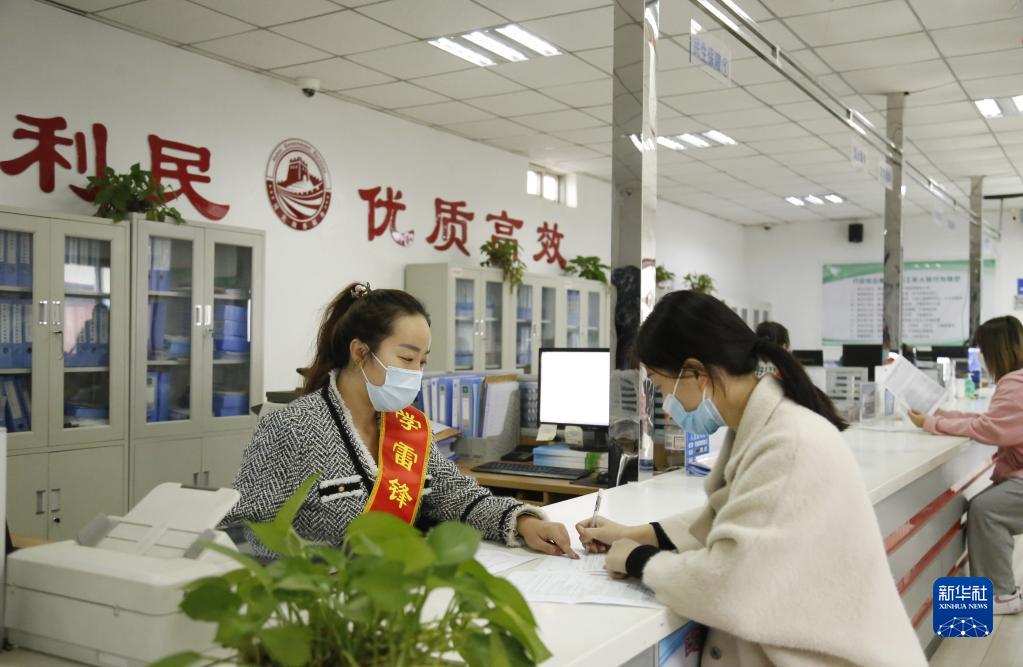 河北省邢臺市襄都區宴家屯鎮綜合服務中心工作人員協助辦事群眾填寫相關表格(2022年3月30日攝)。